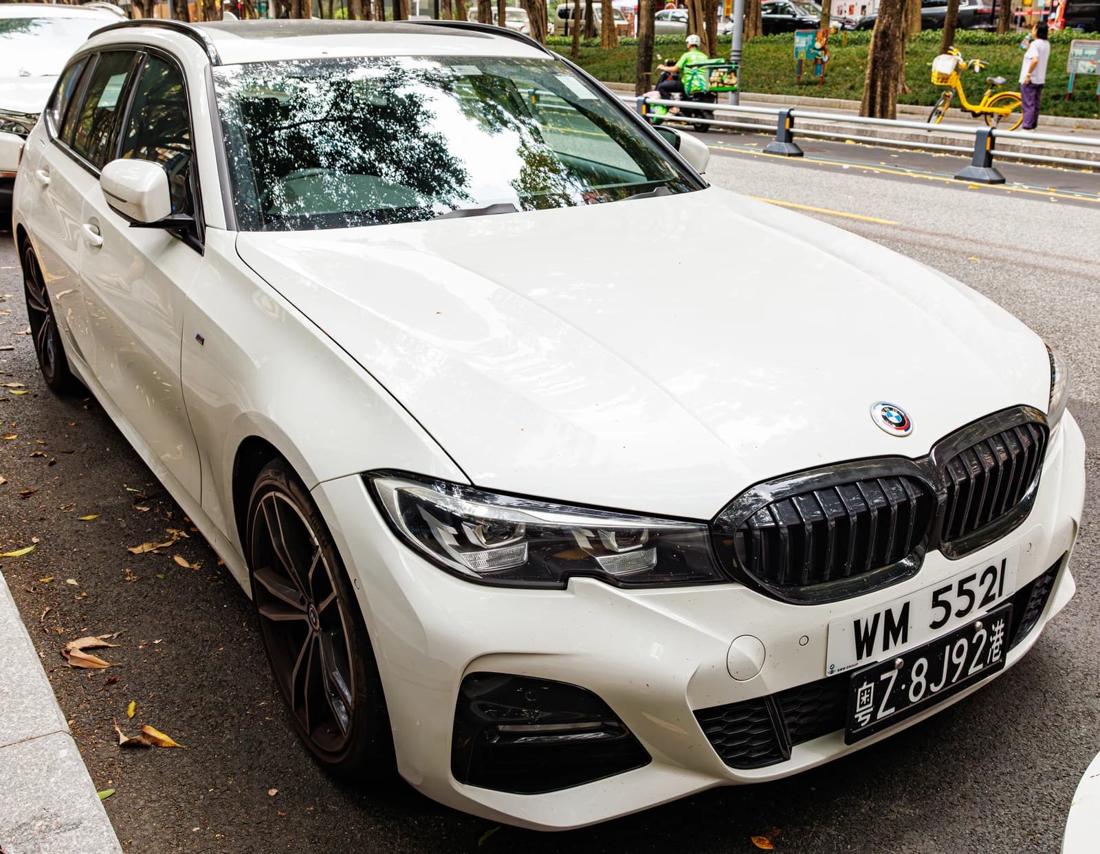 White BMW 3 Series Touring (G21) with Hong Kong license plates parked on a street.
