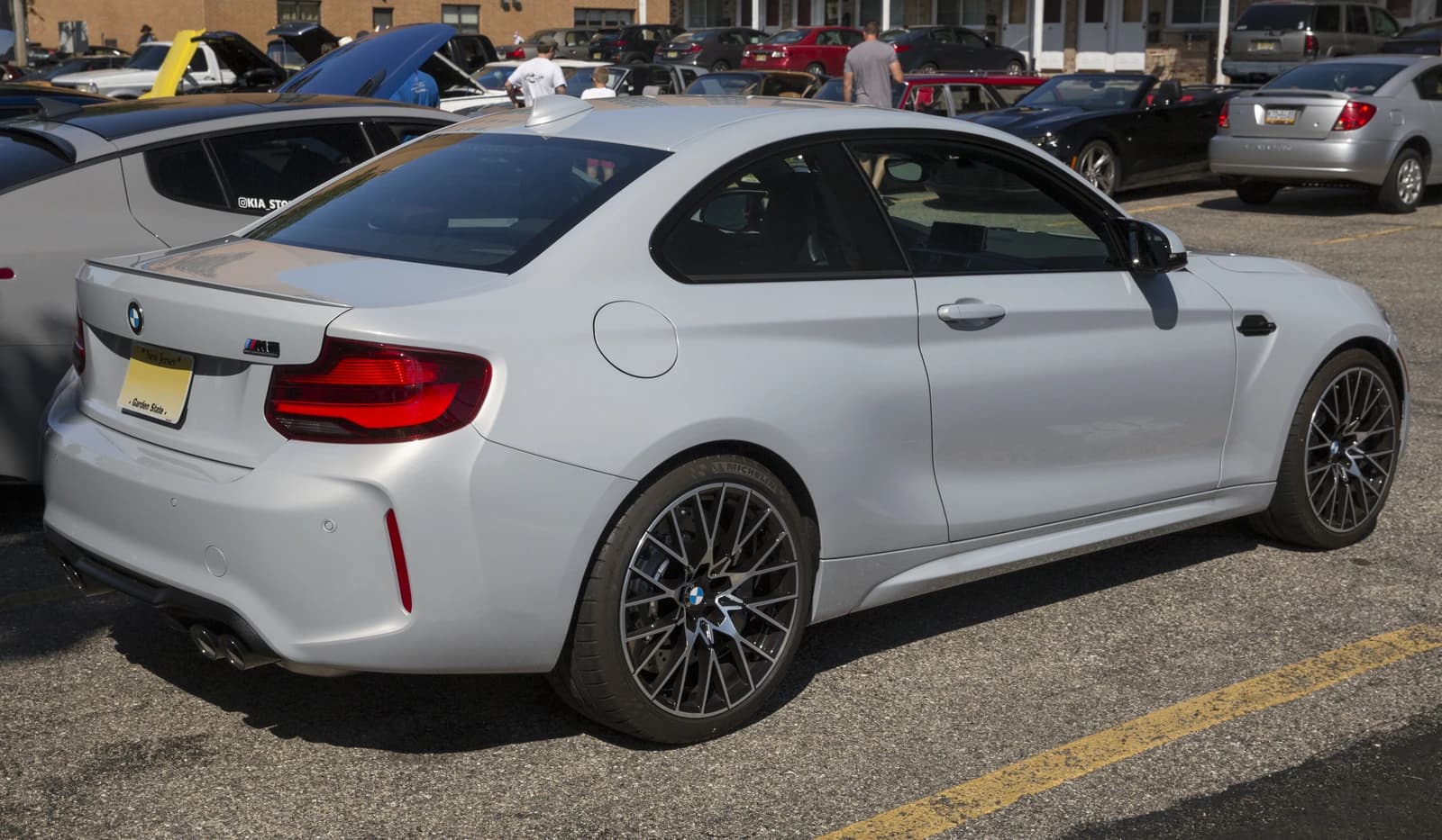 Silver 2020 BMW M2 Competition parked in an outdoor lot on a sunny day.
