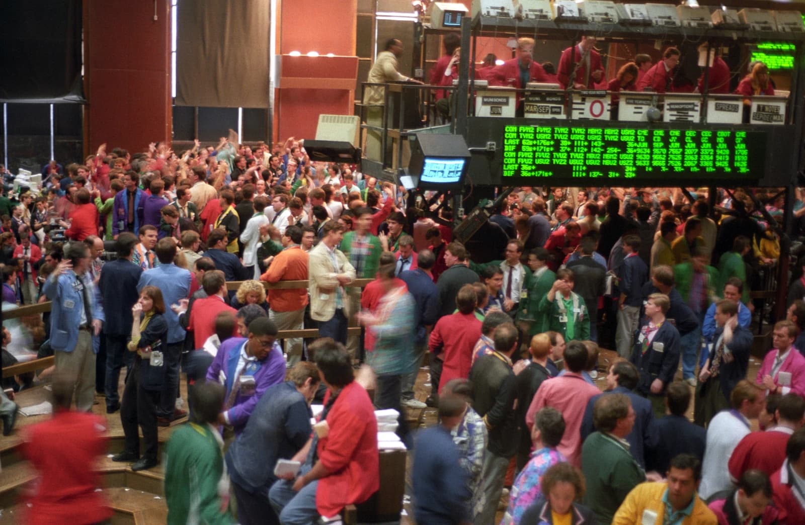 Traders on a crowded commodities futures exchange floor during active trading.