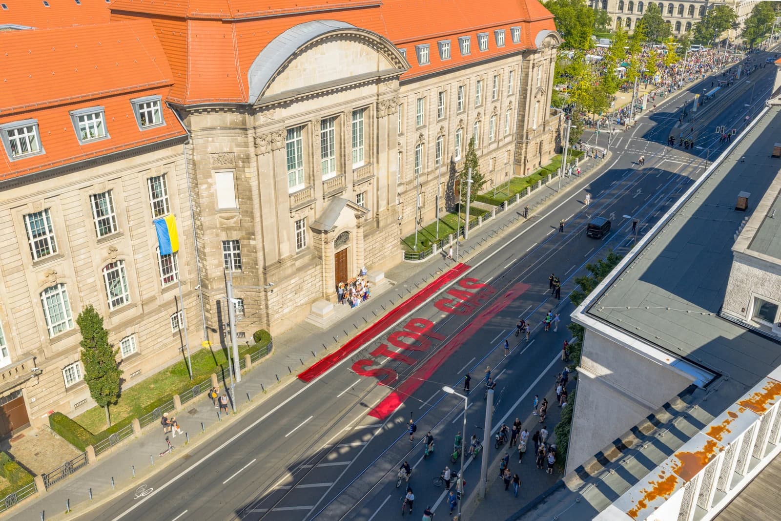 German Ministry for Economic Affairs building with a Ukrainian flag and a 'STOP GAS' protest banner on the street.