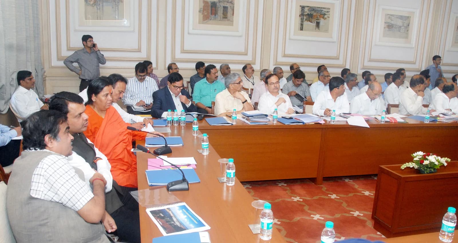 Nitin Gadkari and Devendra Fadnavis seated at a long conference table during a meeting.