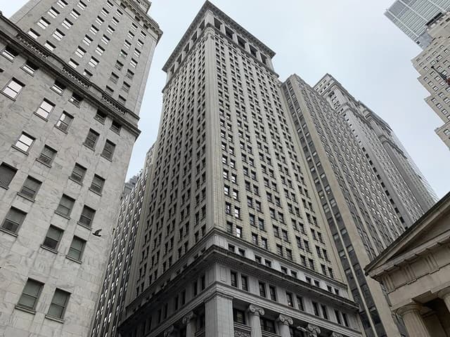 Skyscrapers with numerous windows dominate the Wall Street skyline in New York City.