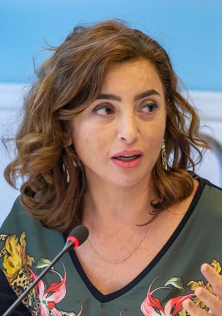 Sandra Nashaat speaking into a microphone at an event.