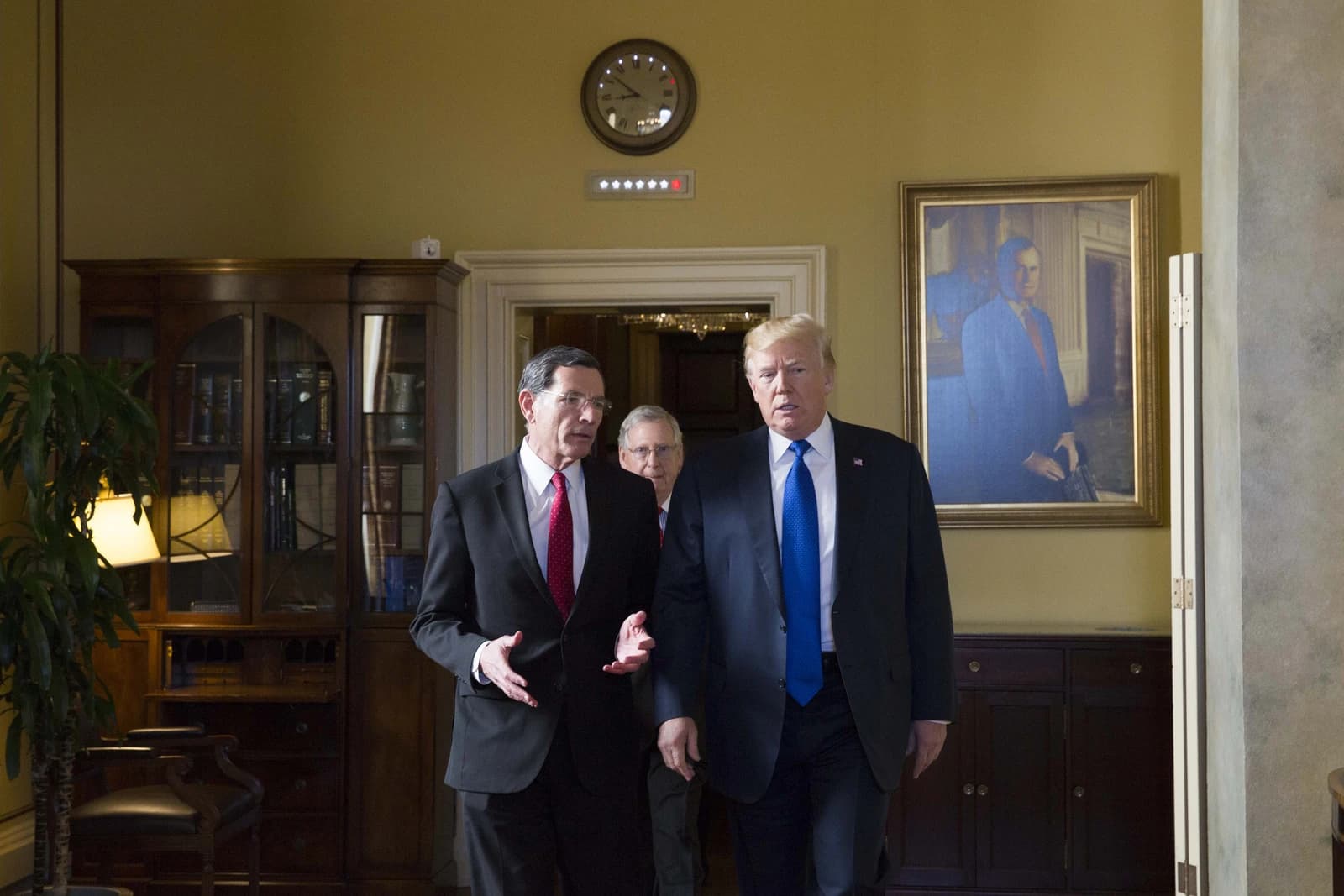 President Donald Trump and Senator John Barrasso walking together in the U.S. Capitol.