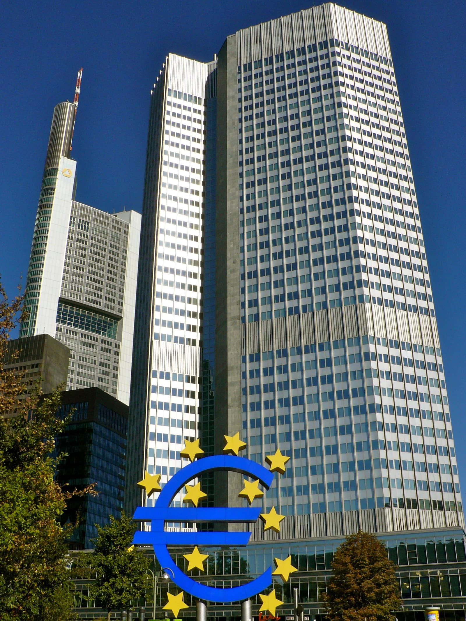 The European Central Bank building in Frankfurt, Germany, with a large Euro symbol sculpture.