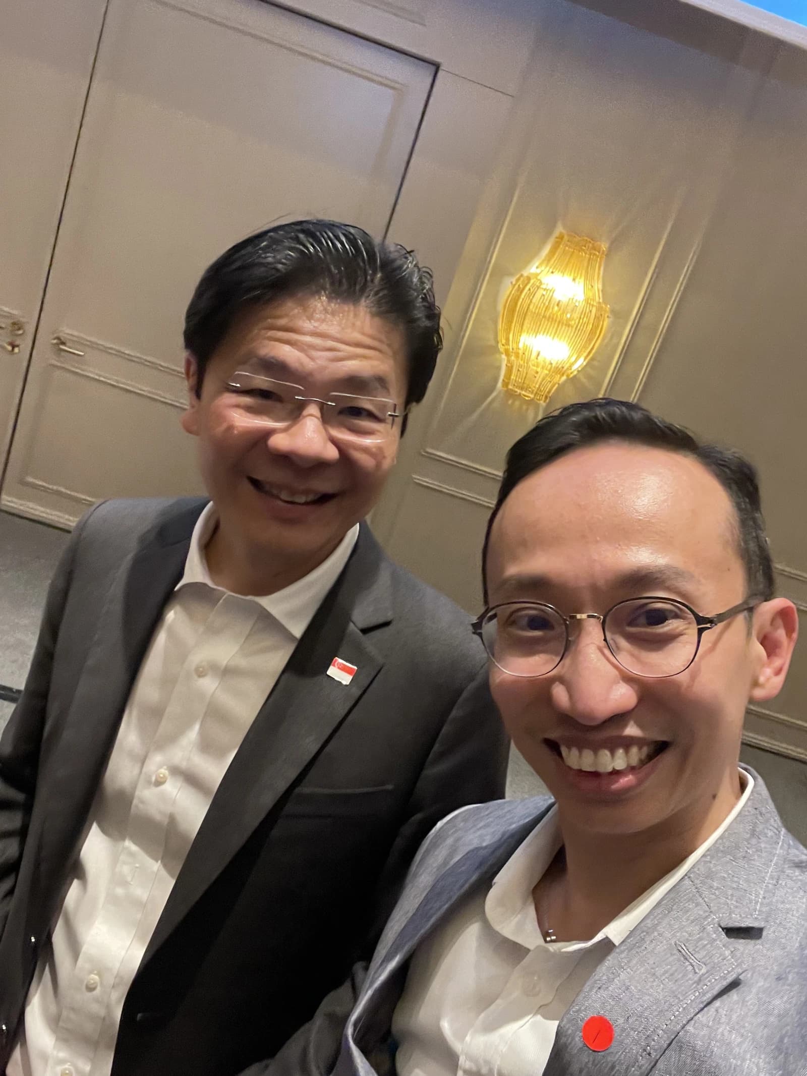 Lawrence Wong, Prime Minister of Singapore, smiling with Alan Ang indoors.