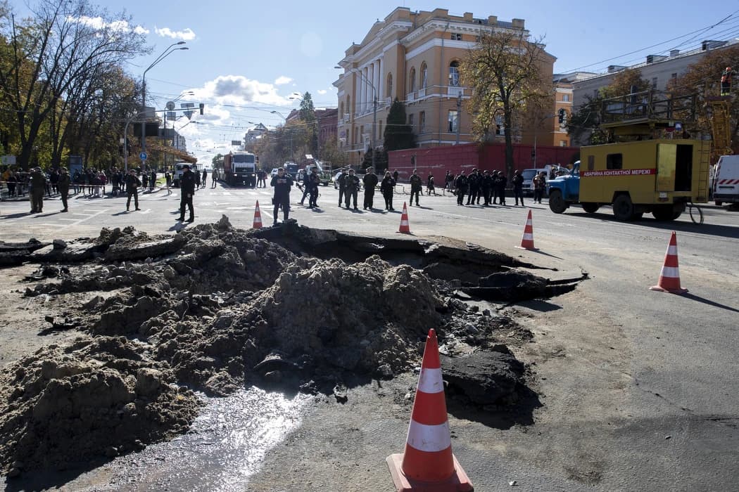 Road in Kyiv showing a large crater and debris after Russian shelling.