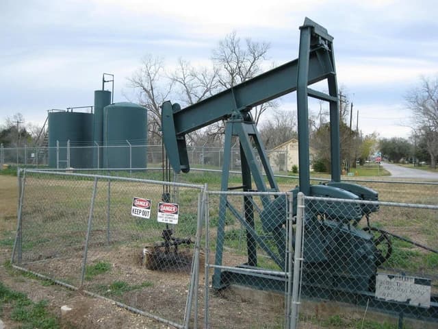 An oil pump jack operating in a rural area in Texas.