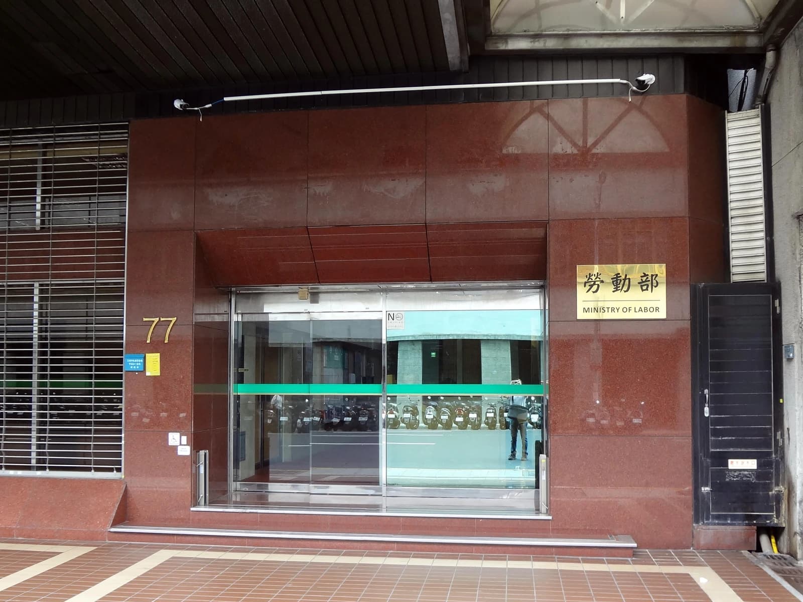 Entrance to the Ministry of Labor building in Taiwan with sign in Chinese and English.