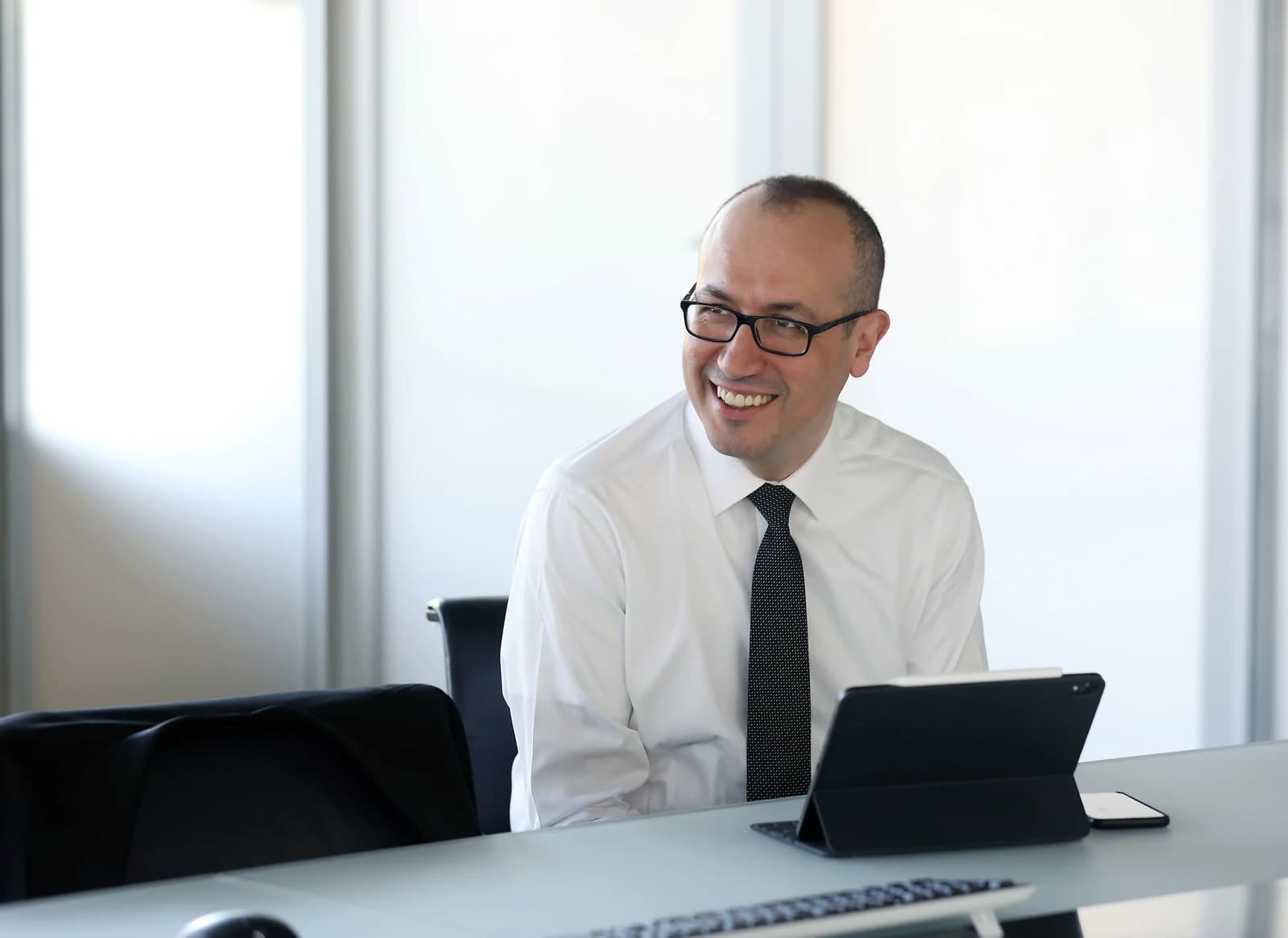Onur Genç, CEO of BBVA, sits at a desk in an office.