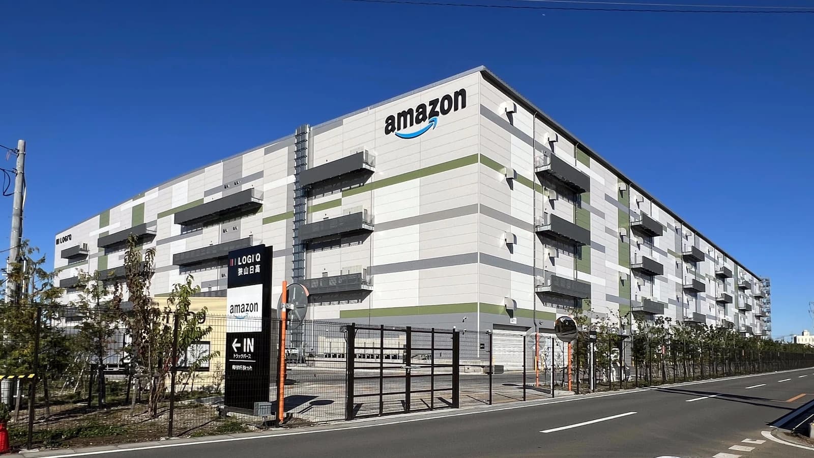 Exterior view of a large multi-story Amazon fulfillment center building.