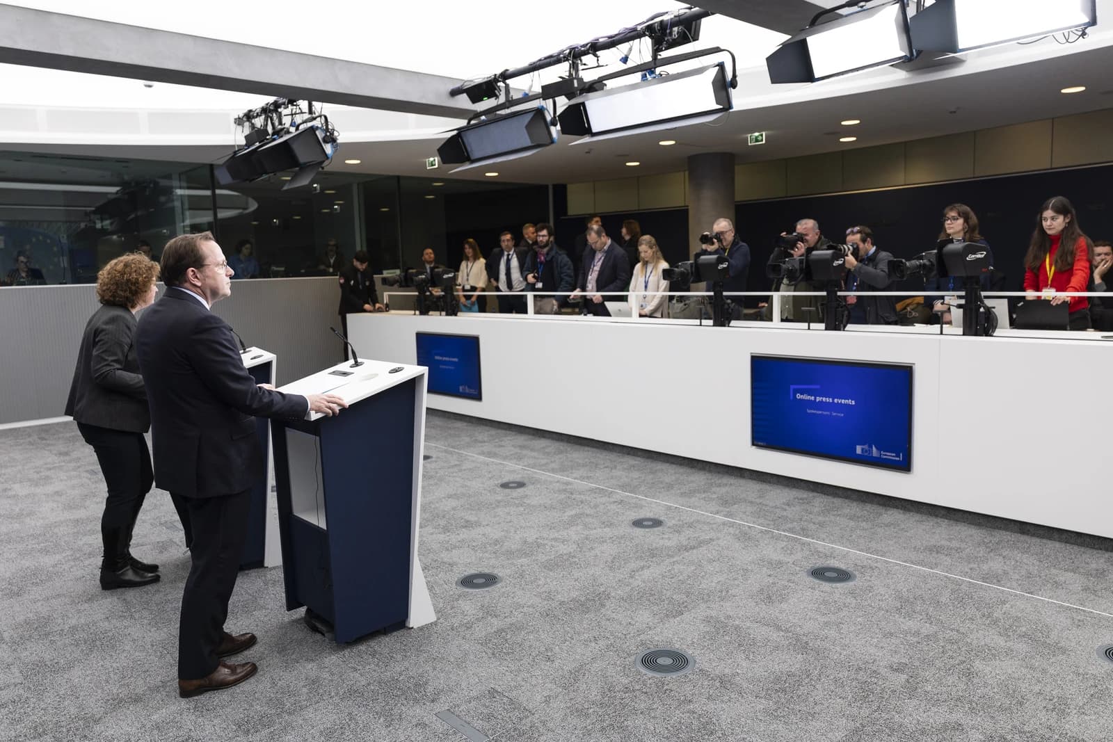 Olivér Várhelyi, European Commissioner, speaking at a podium during a press event.