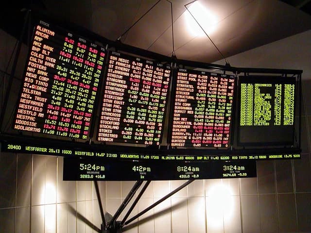 Close-up of an electronic stock ticker board with stock prices and market data.