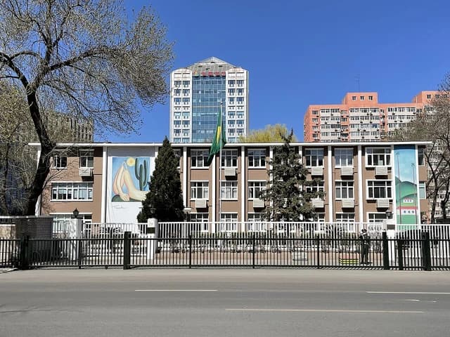 Brazilian Embassy building in Beijing behind a tall black metal fence.
