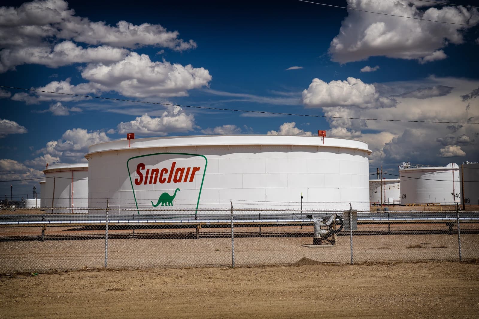 Sinclair Oil refinery storage tanks with the Sinclair logo visible.