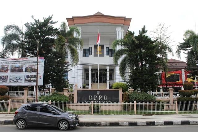 Exterior view of the Banjarbaru City DPRD building with a car on the street.
