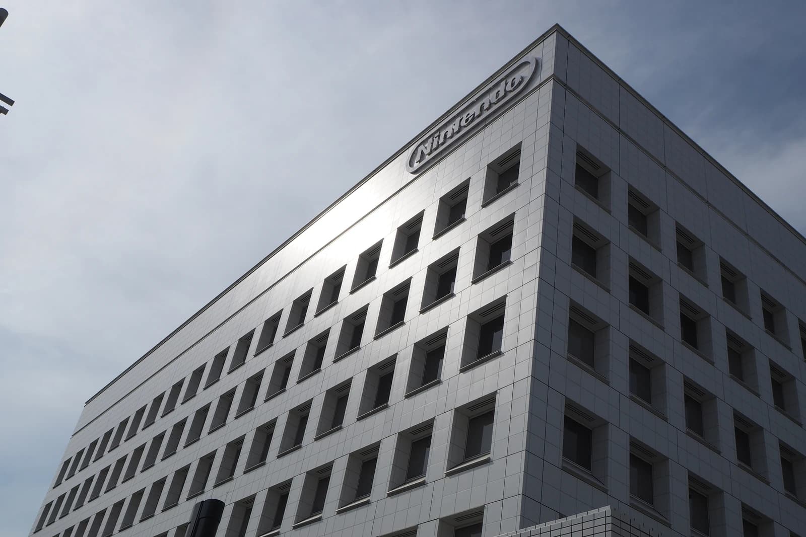 Exterior of the Nintendo Headquarters building with its logo visible on the corner.