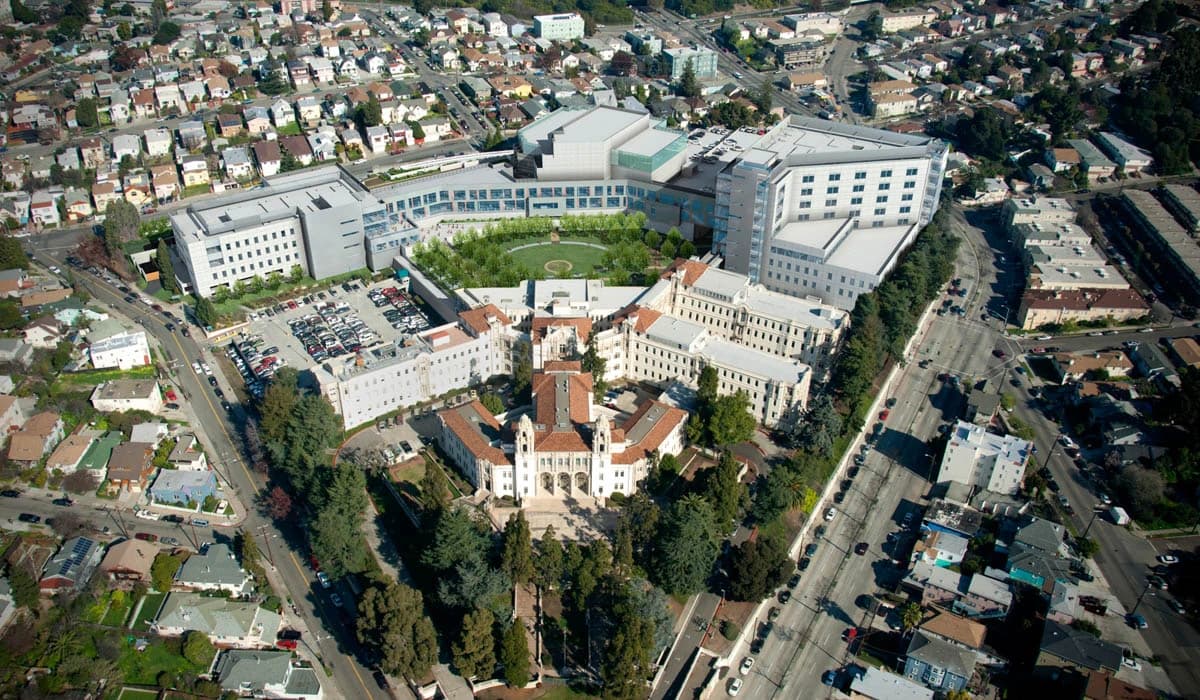 Aerial view of Highland Hospital in Oakland, California, with surrounding buildings and streets.