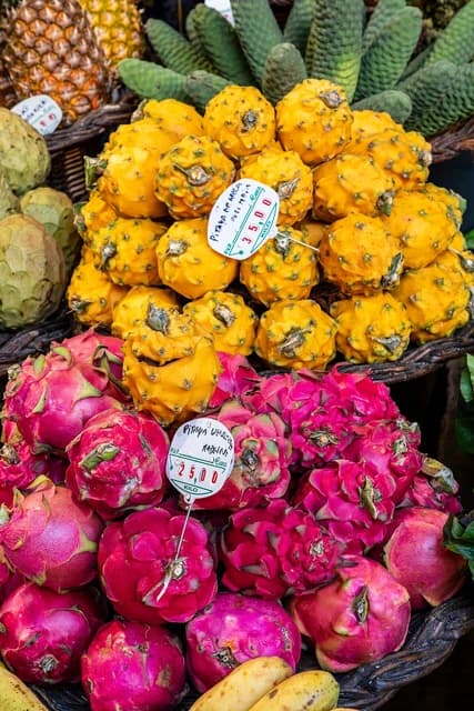 Red and yellow dragon fruit arranged on display at Mercado dos Lavradores in Funchal.