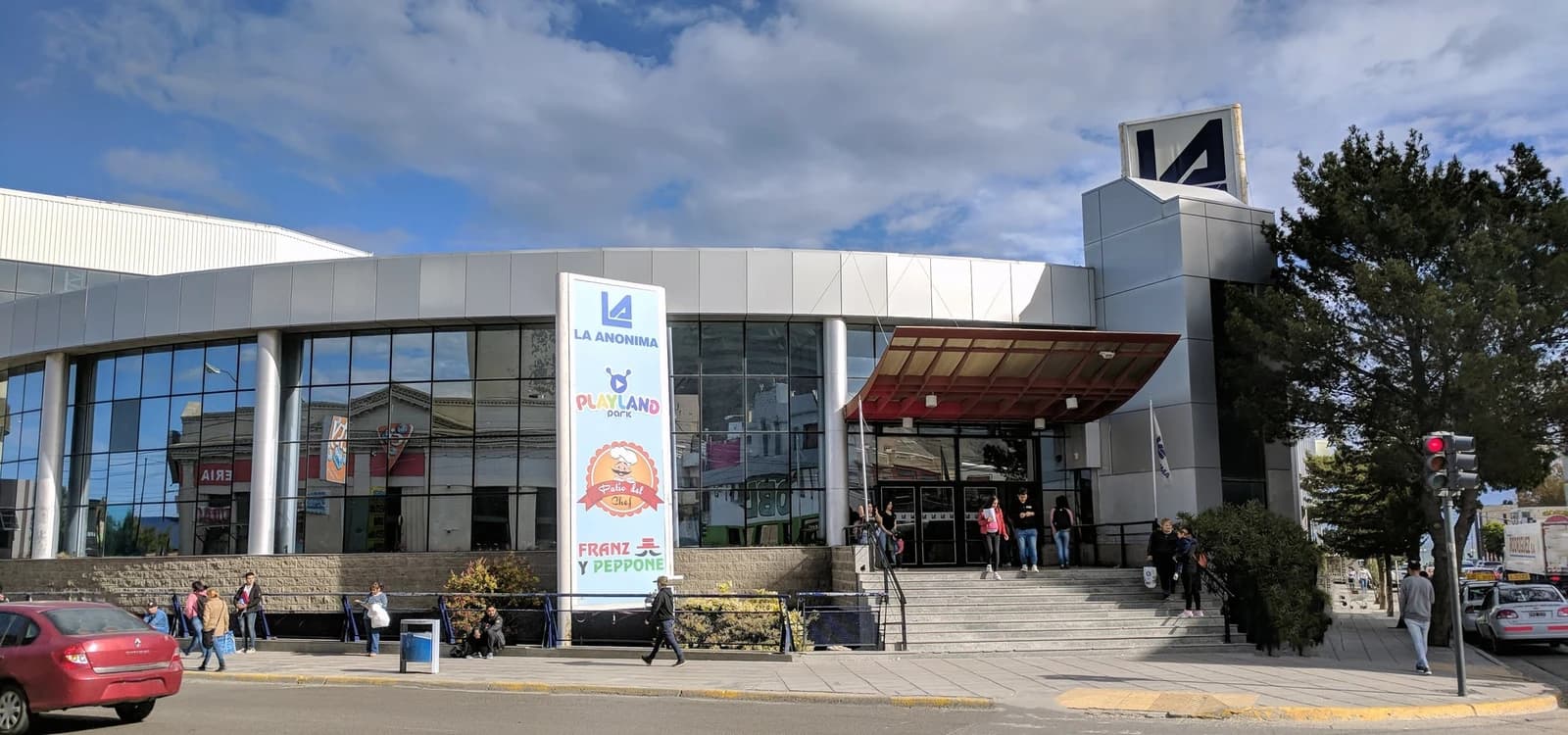 Exterior view of La Anonima supermarket in Comodoro Rivadavia, people entering the building.