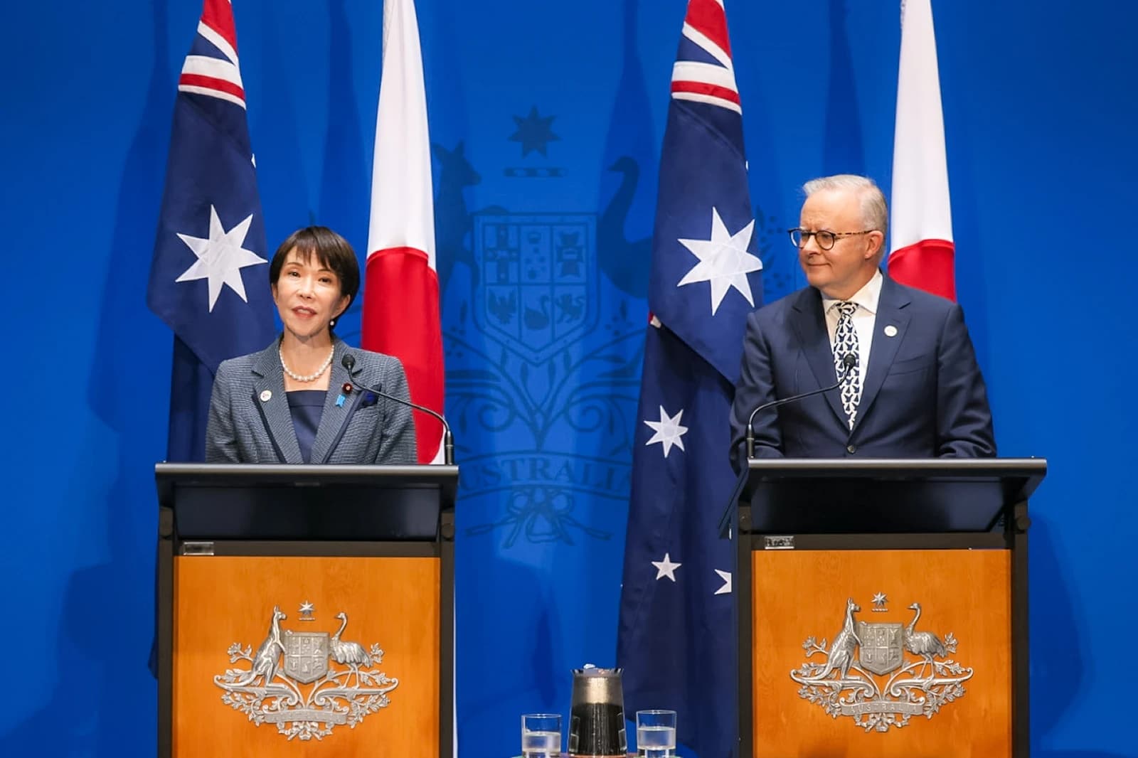 Japanese Prime Minister Sanae Takaichi and Australian Prime Minister Anthony Albanese stand at podiums.