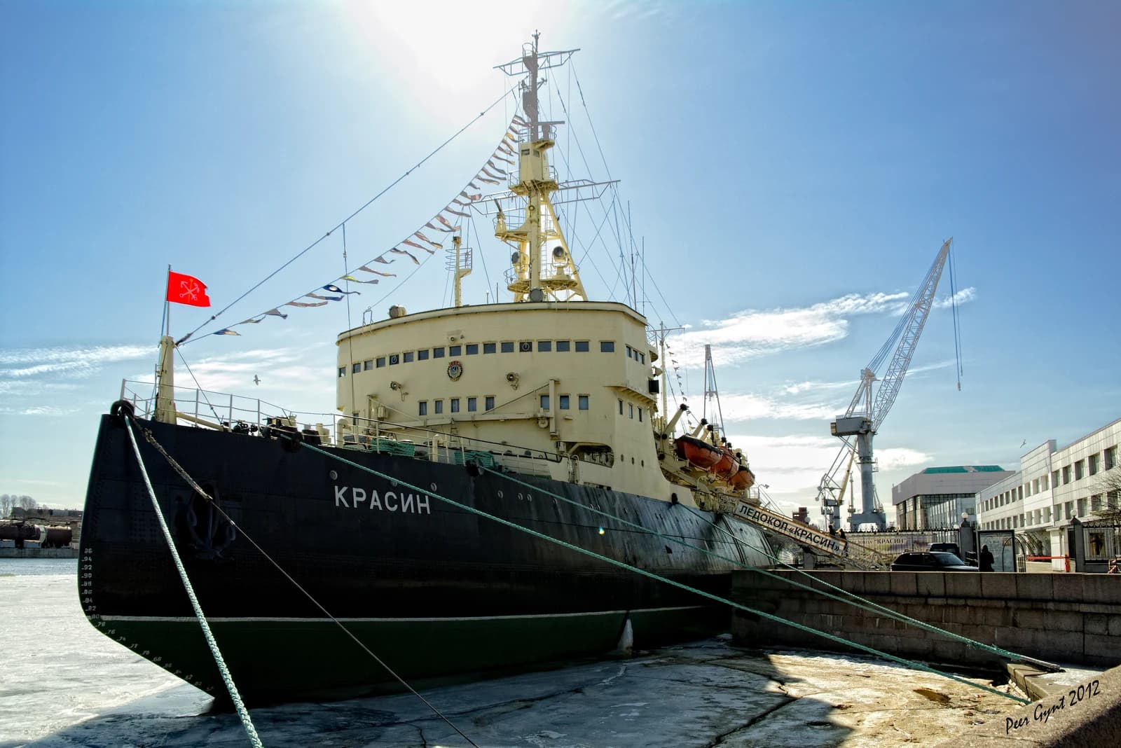 The icebreaker Krasin docked in a port with ice on the water.