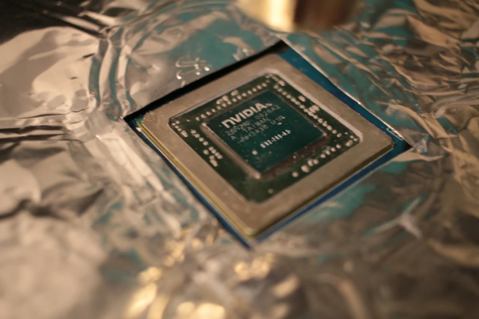 An NVIDIA GPU chip, partially obscured by crumpled foil.
