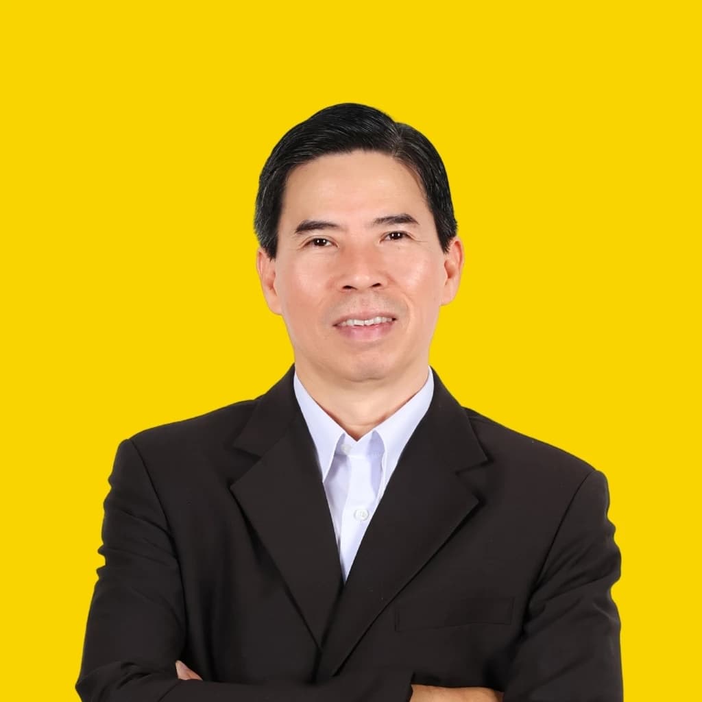 Nguyen Duc Tai, an individual, stands with arms crossed against a plain yellow background.