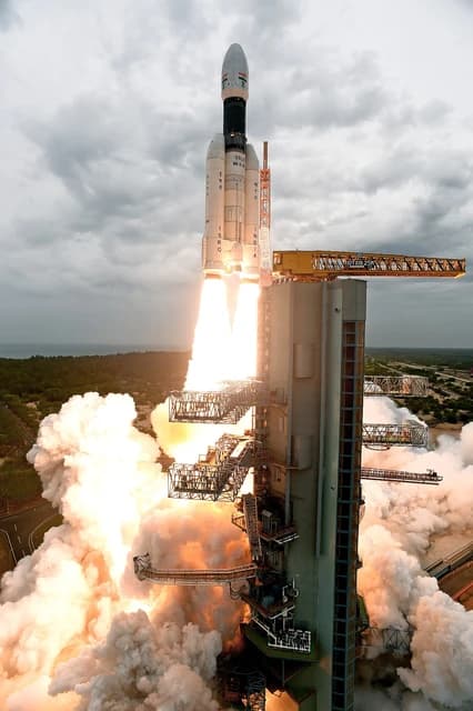 Indian GSLV Mk III M1 rocket launching Chandrayaan-2 from a launchpad.