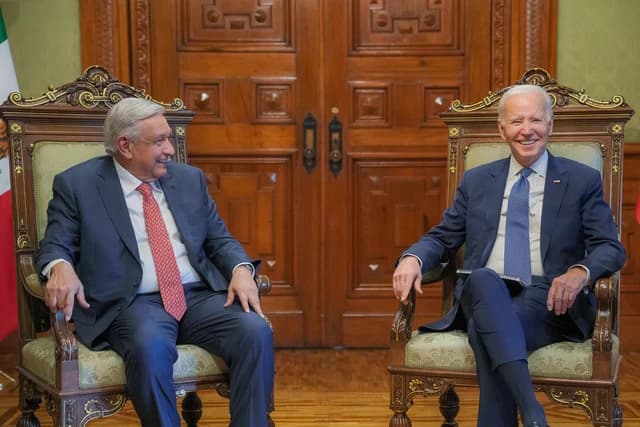 President Joe Biden and President Andrés Manuel López Obrador seated indoors, smiling and looking to the left.