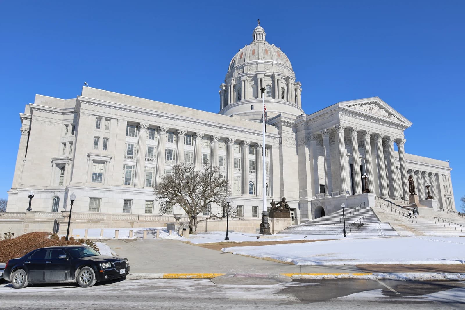 Missouri State Capitol building with its dome and columns, surrounded by snow.