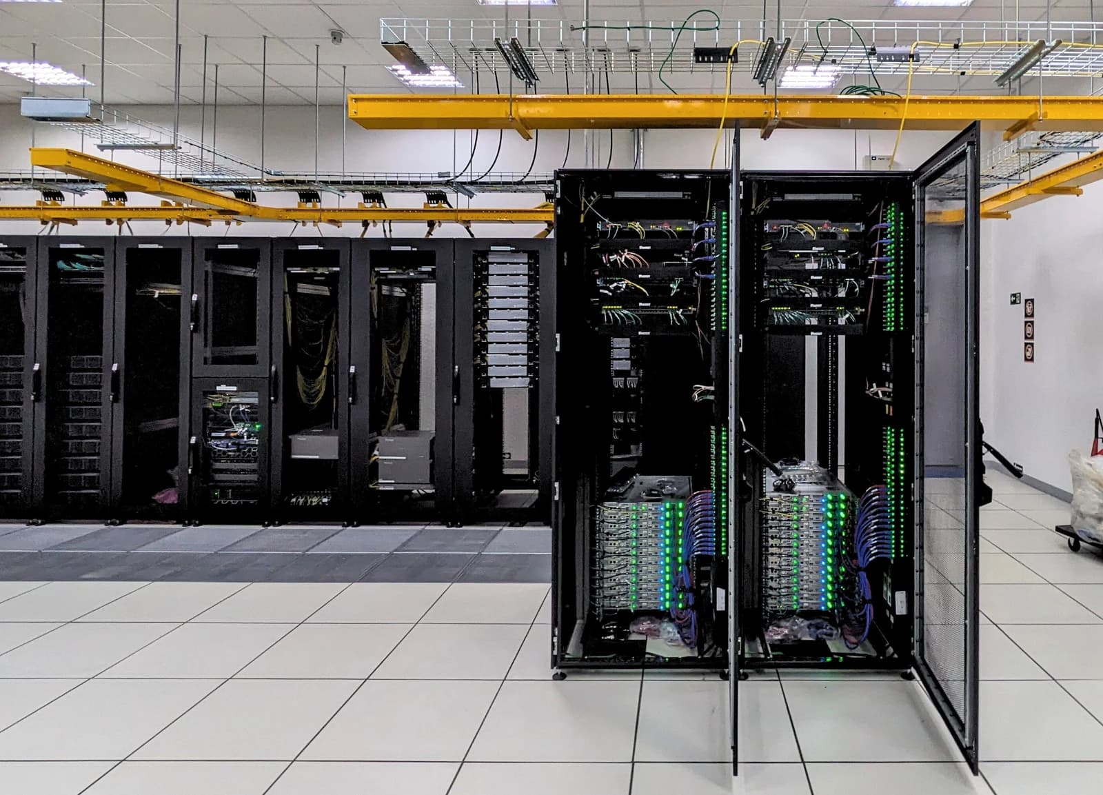 Interior of a data center with rows of server racks displaying blinking lights.