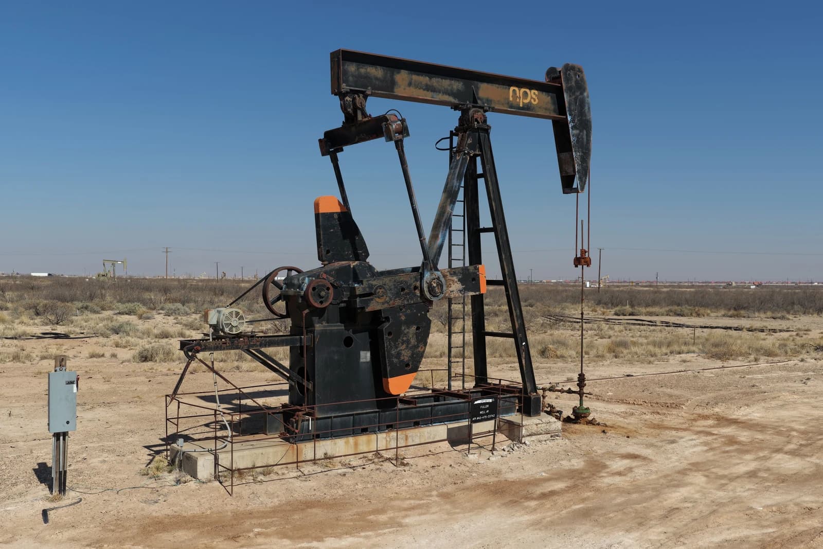 An oil pumpjack extracts crude oil in the vast Permian Basin landscape.