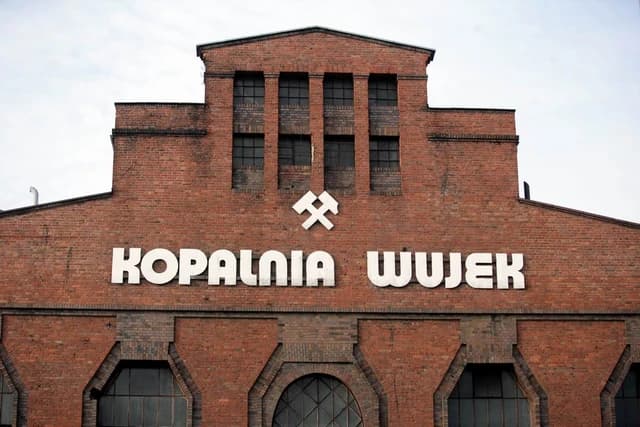 Exterior of the Wujek Coal Mine building in Poland, featuring signage.