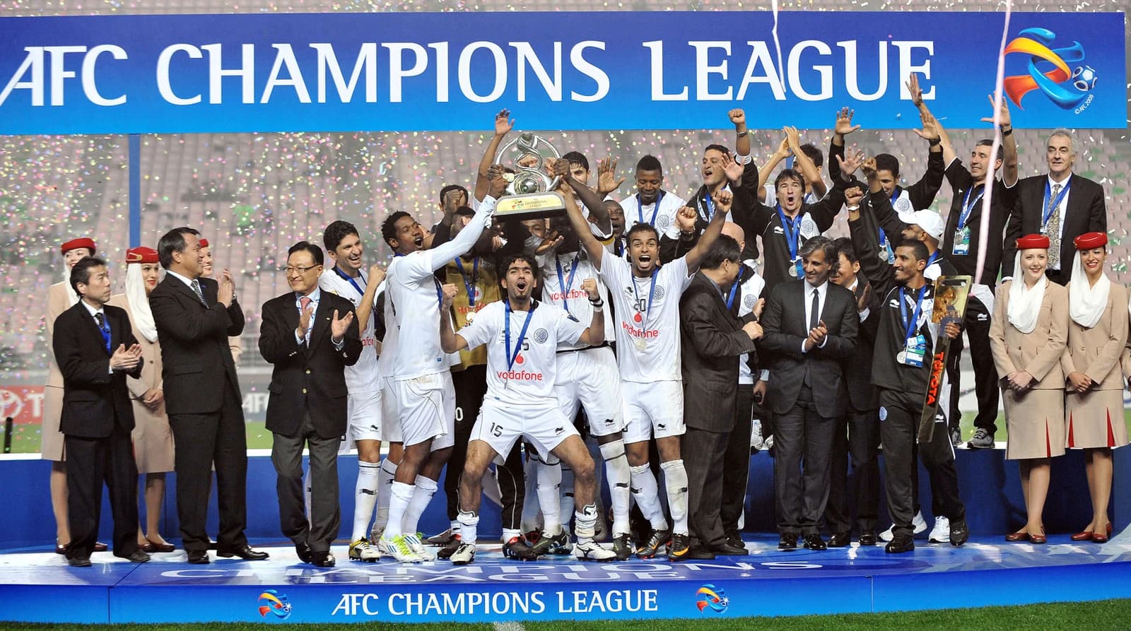 Al Sadd football team players and officials celebrating with the AFC Champions League trophy.