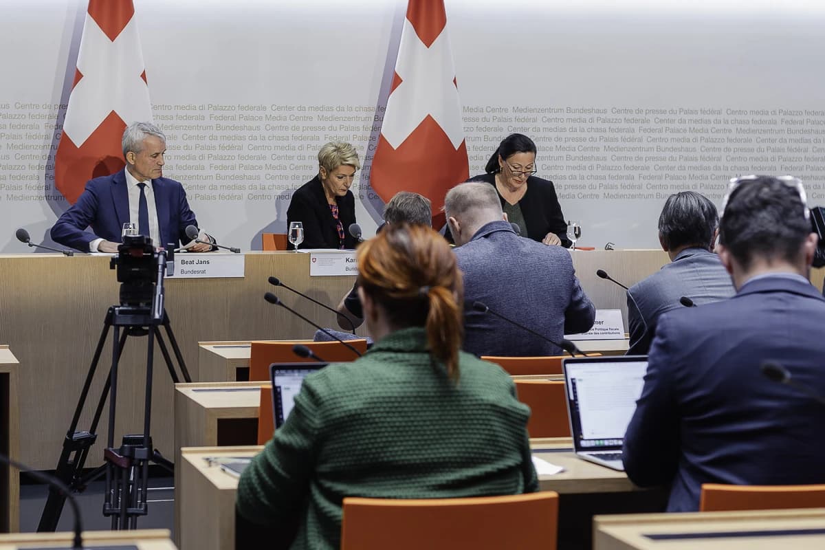 Beat Jans, Swiss Federal Councillor, sitting at a table with microphones during a press conference.