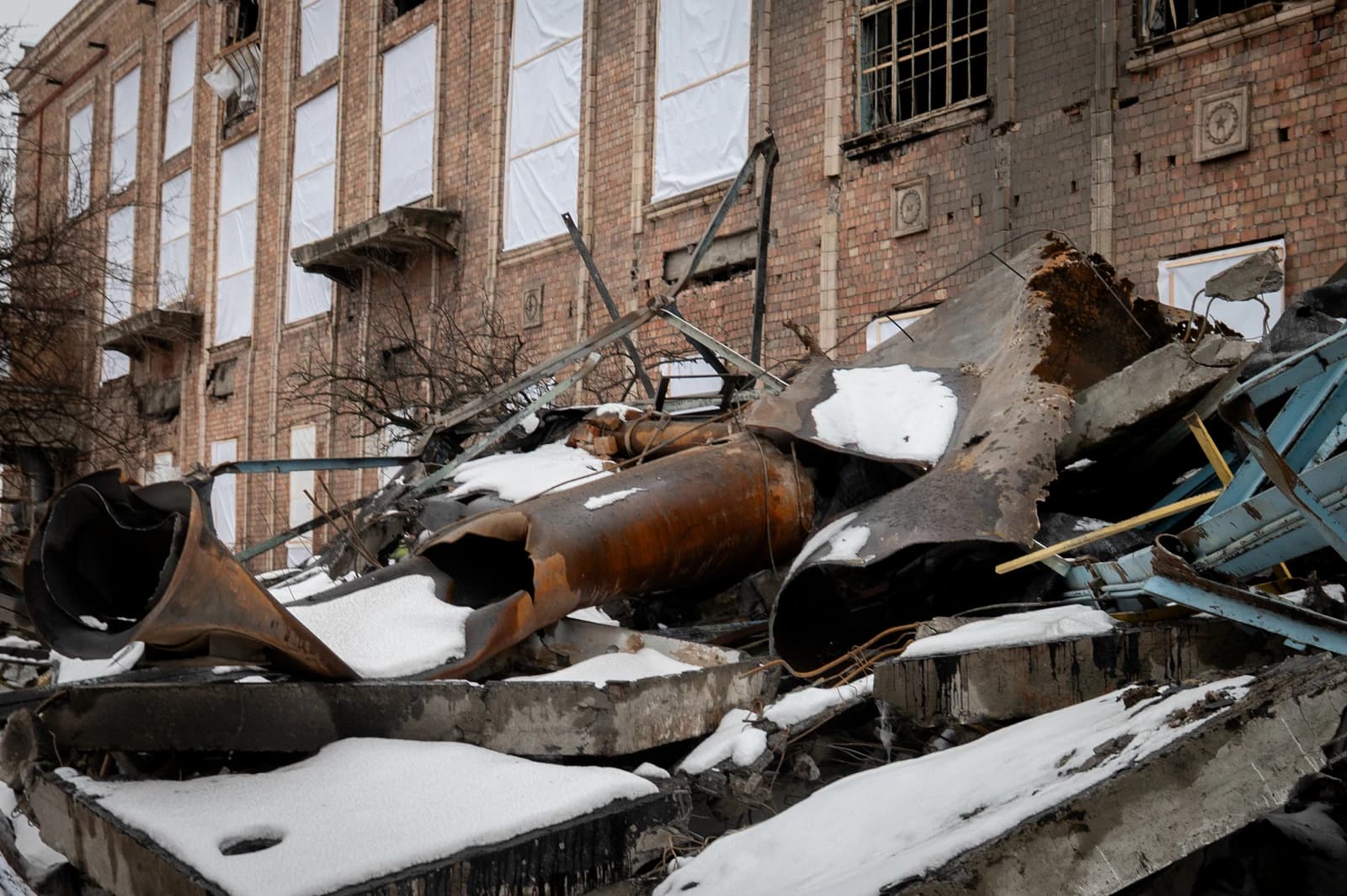 Debris and damaged structures at Darnytska Combined Heat and Power Plant in Kyiv, with snow.