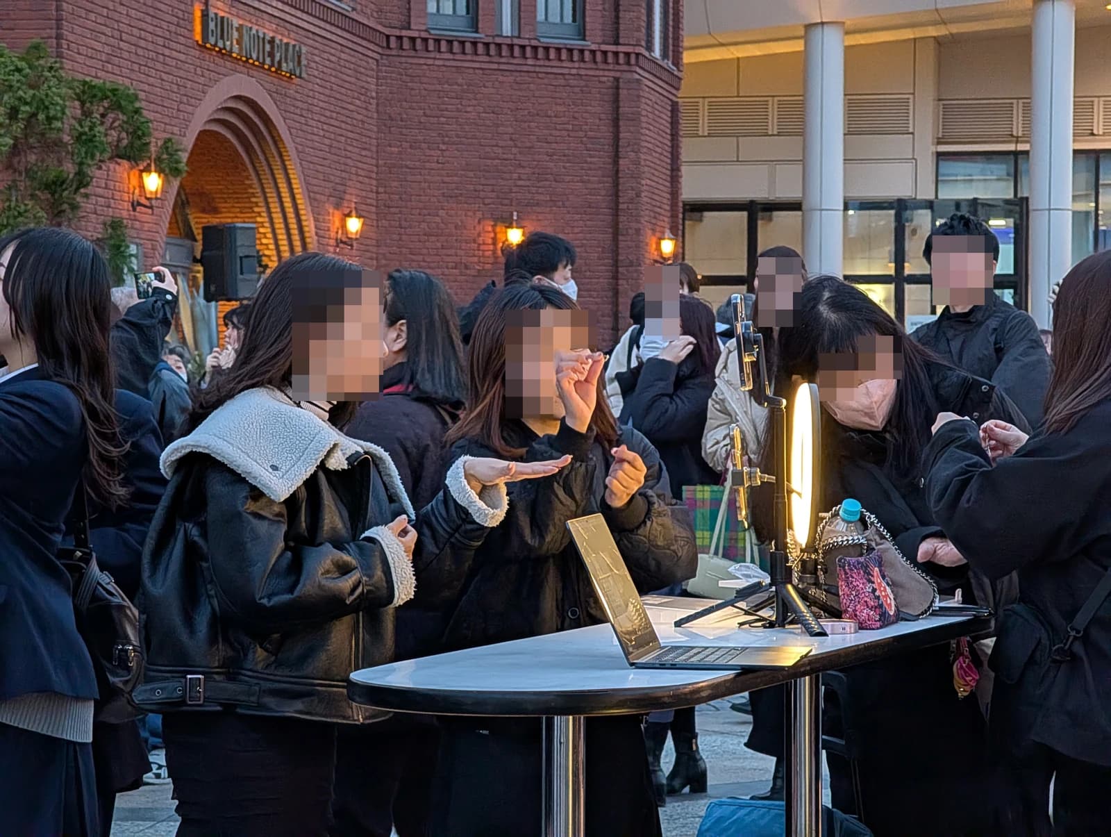 Influencers showcasing jewelry with a laptop and ring light in Yebisu Garden Place.