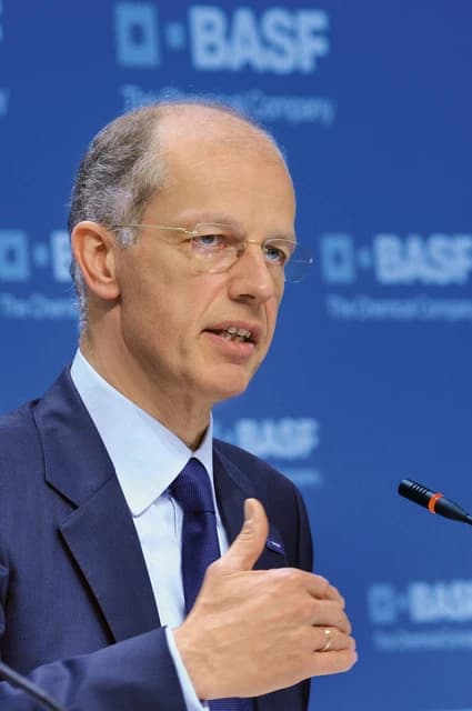 Kurt Bock, CEO of BASF, speaking at a press conference with a microphone.