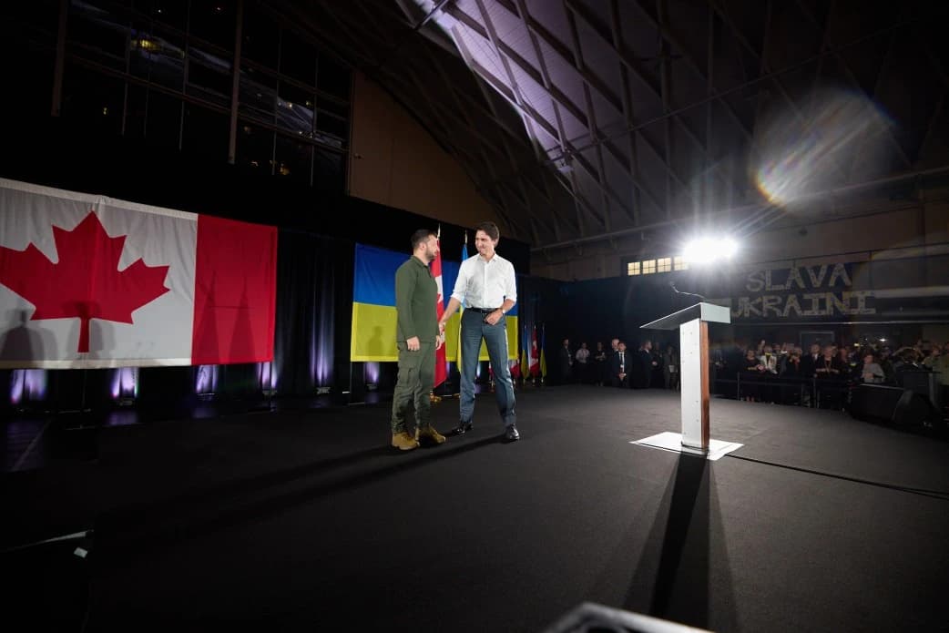 Ukrainian President Volodymyr Zelenskyy and Canadian Prime Minister Justin Trudeau shaking hands on a stage.