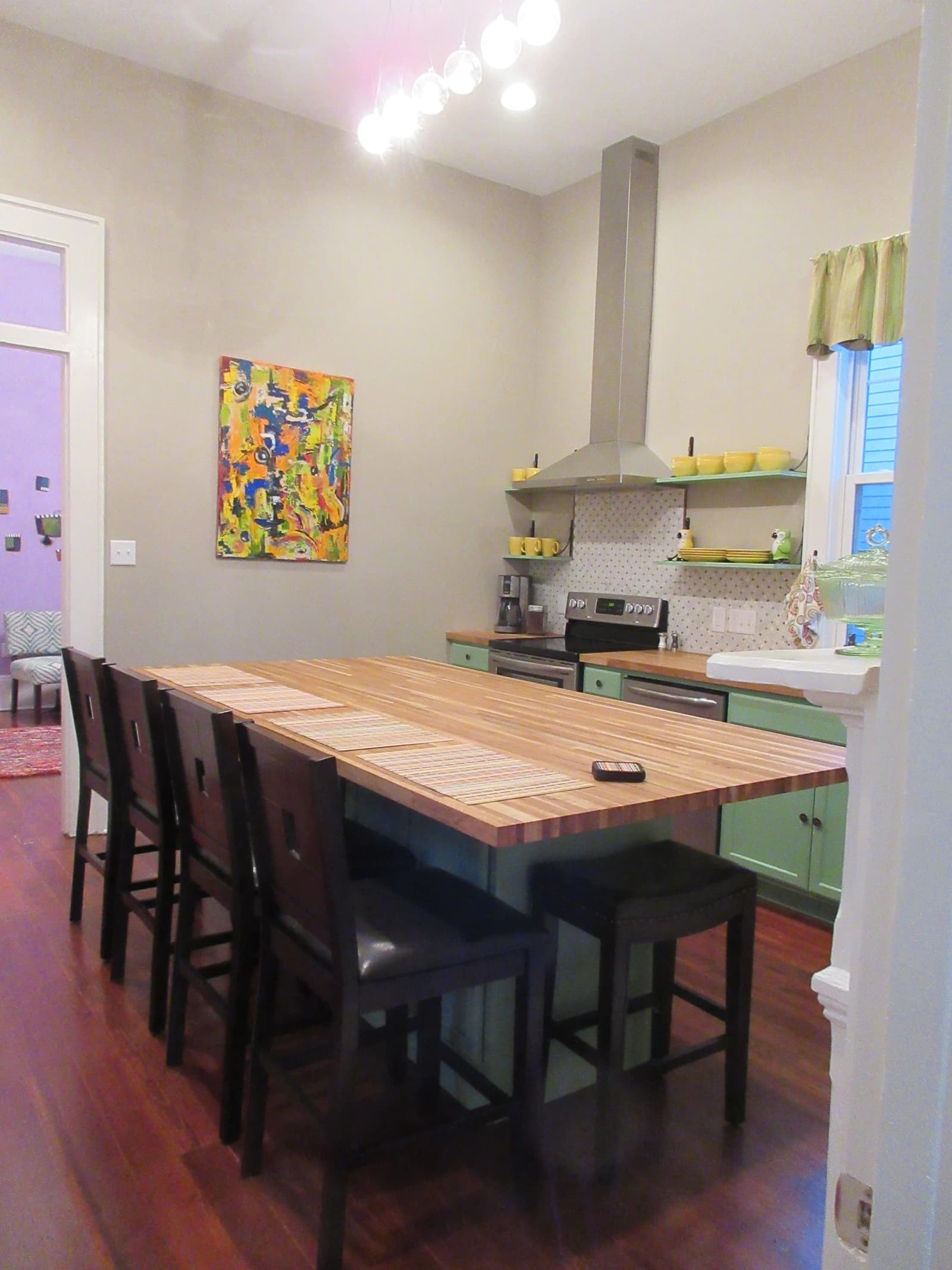 Kitchen interior with a large butcher block island and modern appliances.