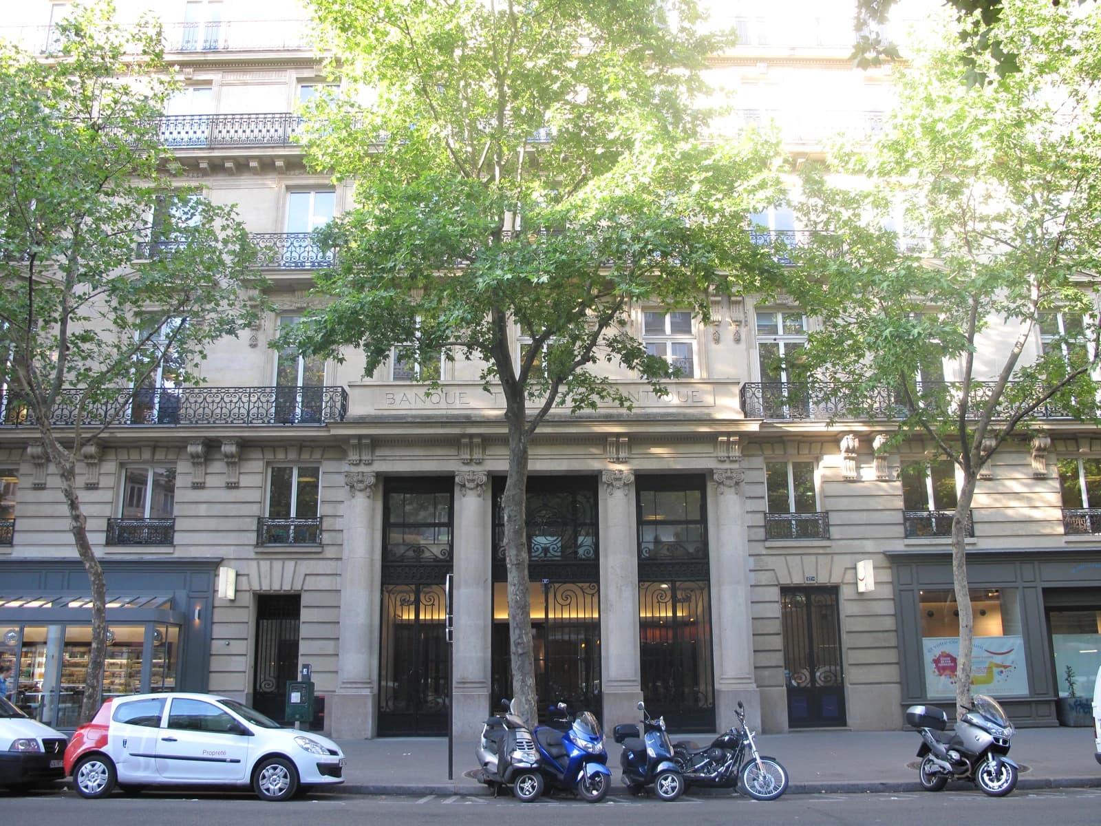 Exterior view of a building with 'BANQUE' engraved above its entrance on a Paris street.