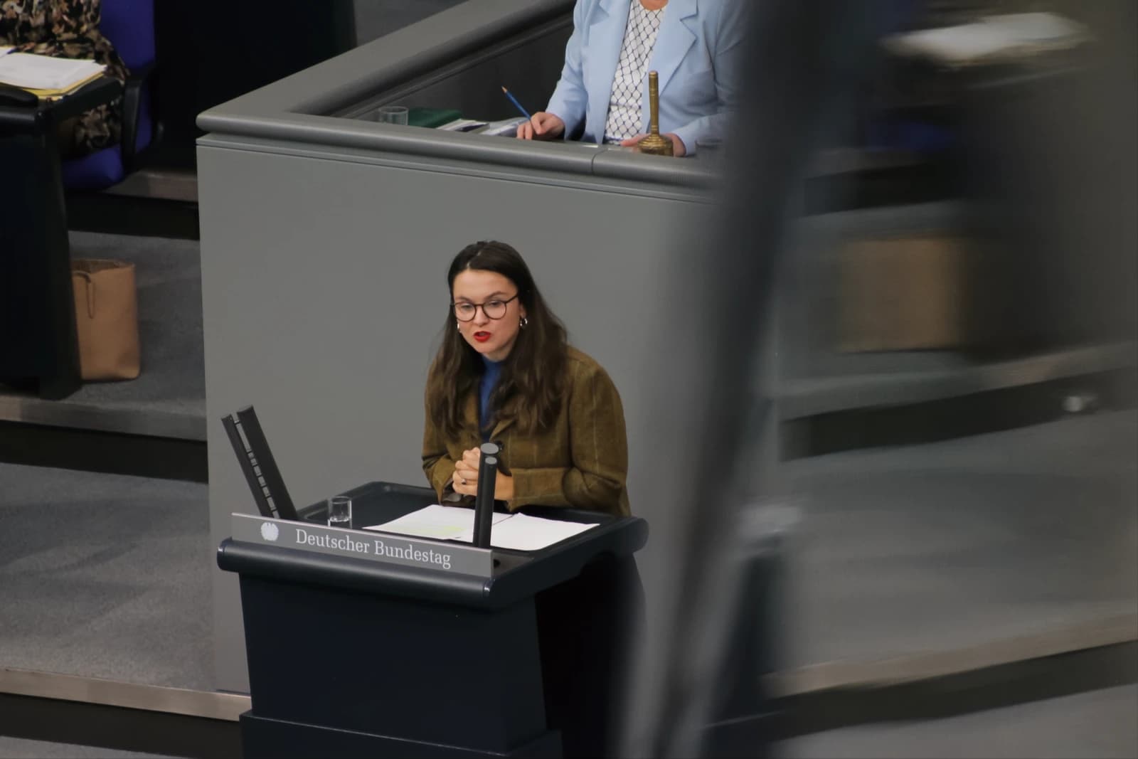 Anna Aeikens, MdB, speaking at a podium in the German Bundestag in Berlin.