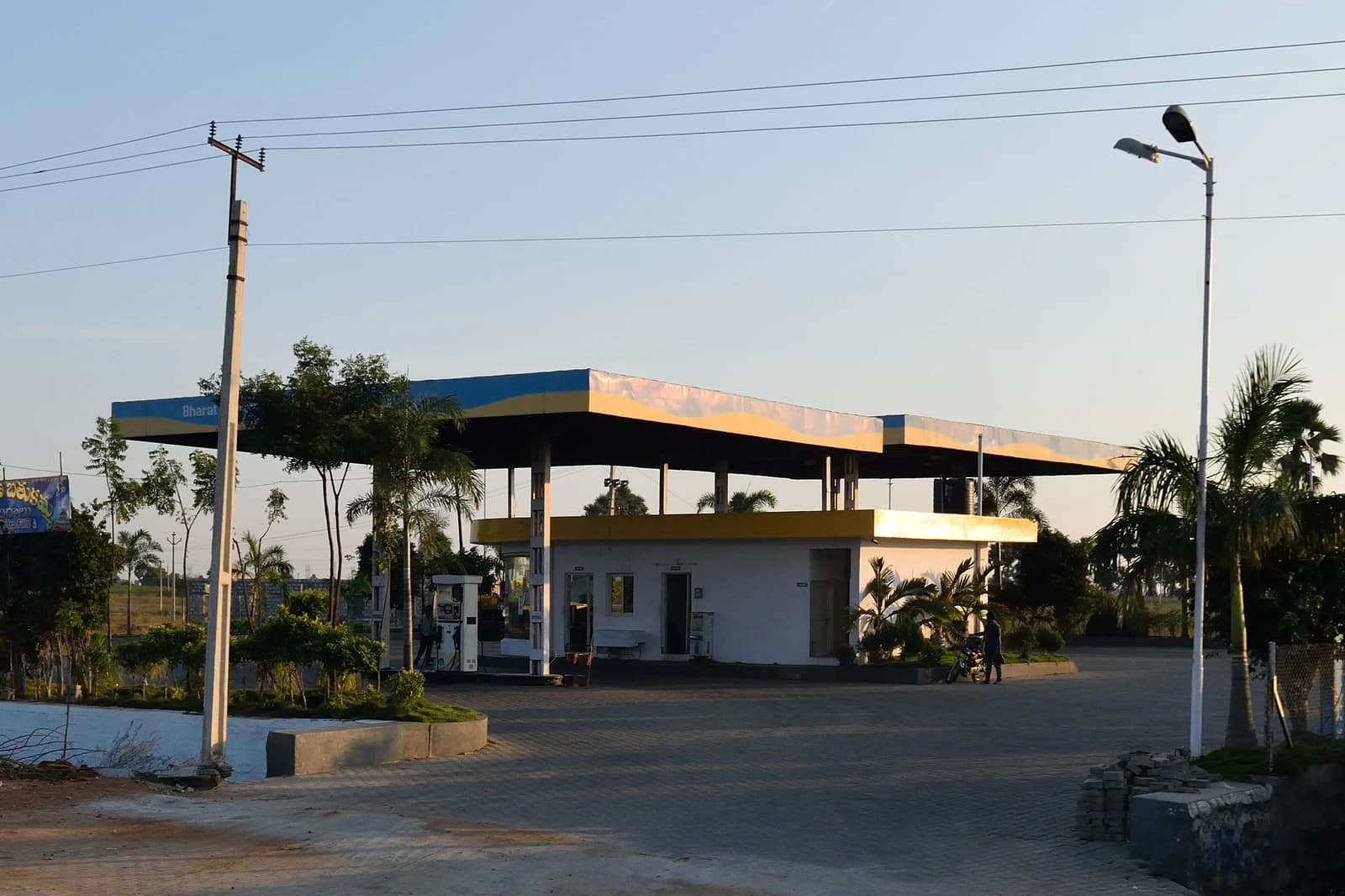 A Bharat Petroleum petrol station with multiple fuel pumps under a yellow and blue canopy.