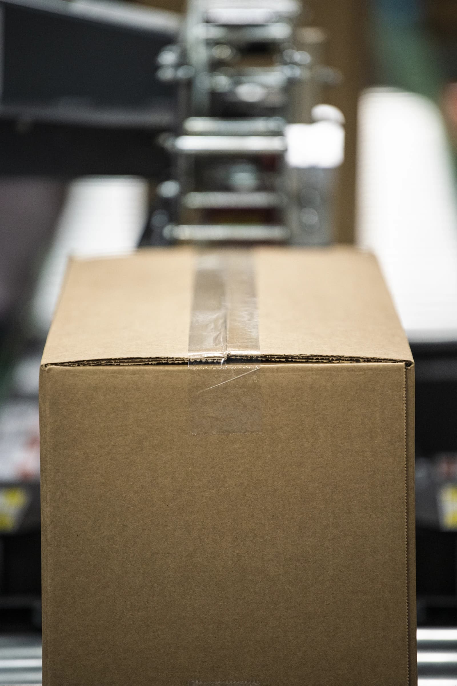 A sealed cardboard box moving along a conveyor belt in a food packaging facility.