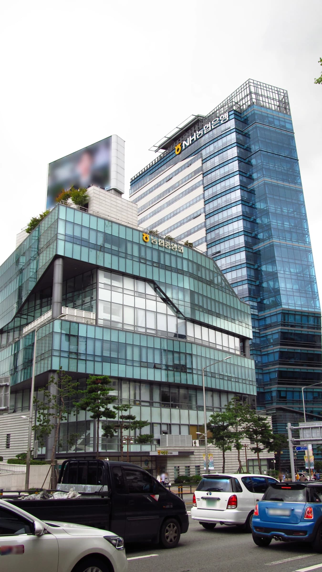 Exterior view of the NH Nonghyup Bank building in a city setting.