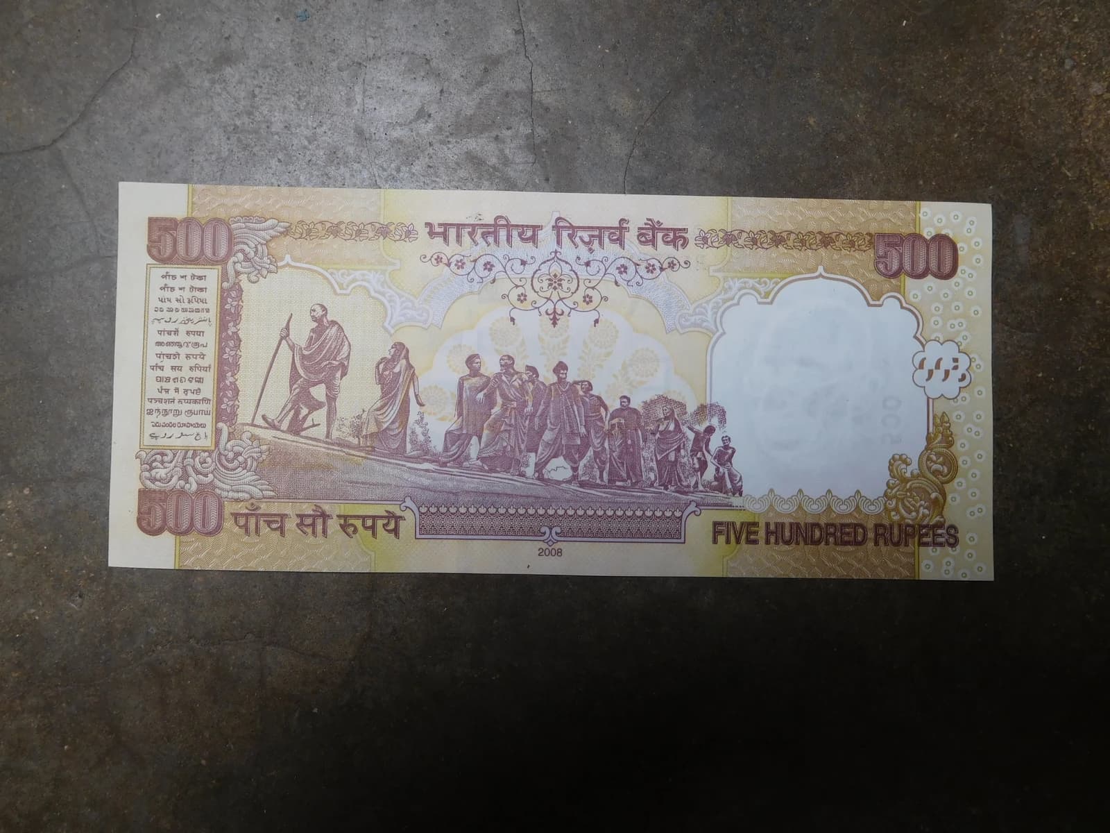 Indian 500 Rupee banknote showing Mahatma Gandhi and the Dandi March scene.