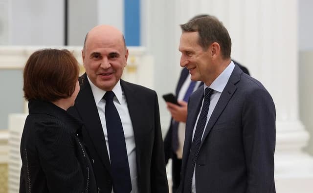 Elvira Nabiullina, Mikhail Mishustin, and Sergey Naryshkin speaking at an indoor event.