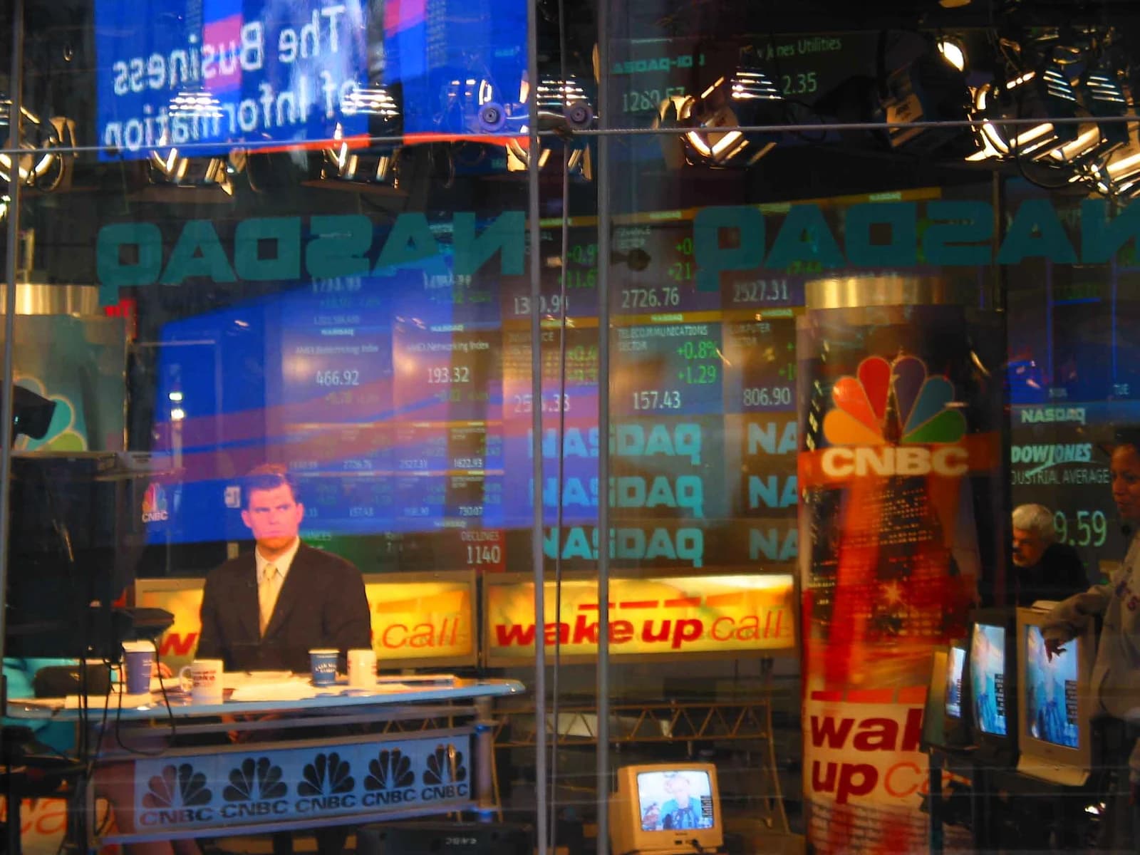 A man in a suit seated at a news desk at the NASDAQ MarketSite.