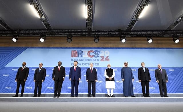 Heads of delegations from various countries standing in a line on a stage.
